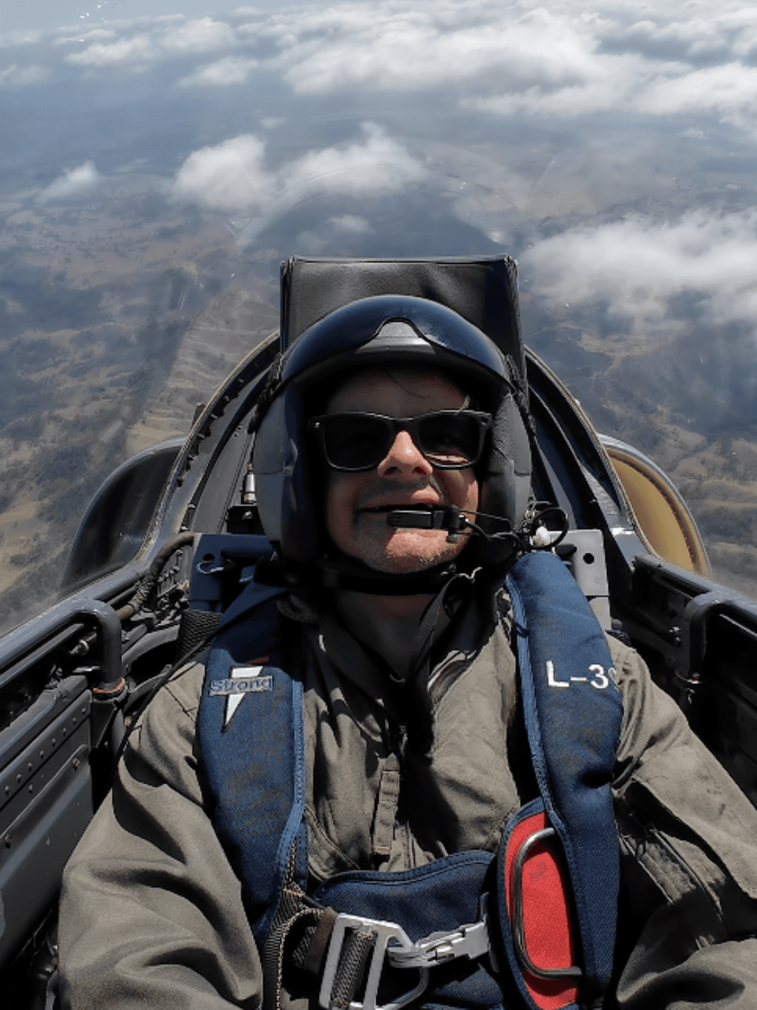 Greg Cassar piloting an L-39 jet trainer above the clouds — life by design.