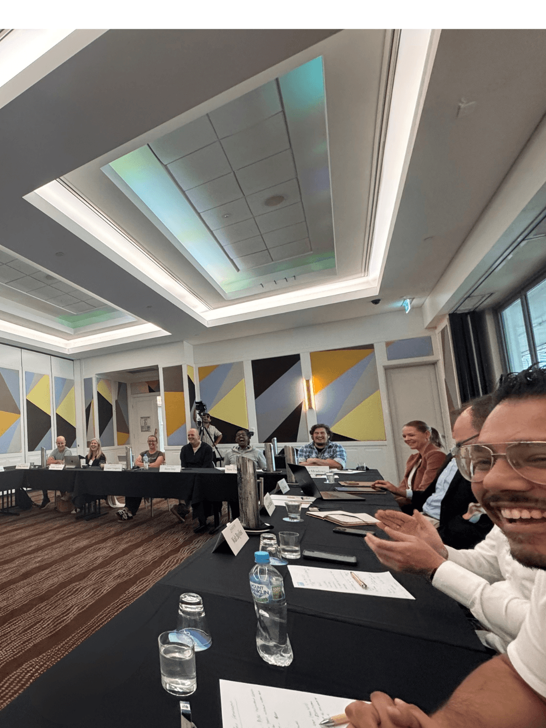 Collective members seated around a conference table during a structured mastermind session in a professional hotel meeting room.